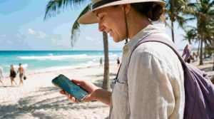 Tourist using smartphone with mobile internet in Cancun Mexico