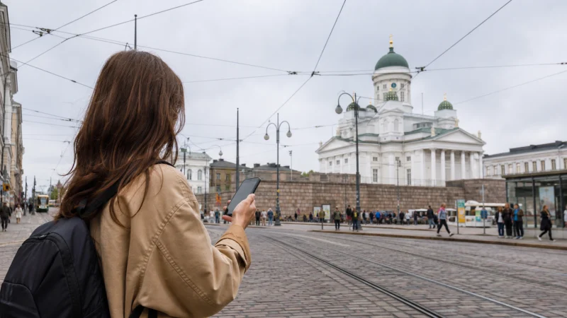 Tourist using mobile internet while exploring central Helsinki