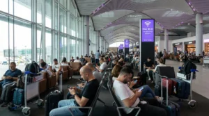 Passengers using WiFi on smartphones inside Istanbul Airport terminal