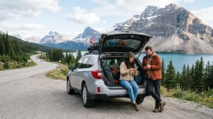 Travelers using mobile internet during a Canada roadtrip with mountains lakes and scenic highway
