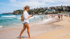 Tourist using mobile internet at Bondi Beach in Sydney Australia