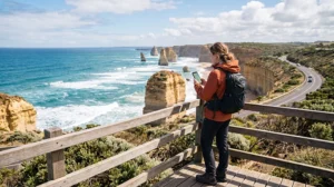 Traveler using mobile internet while driving along the Great Ocean Road in Australia