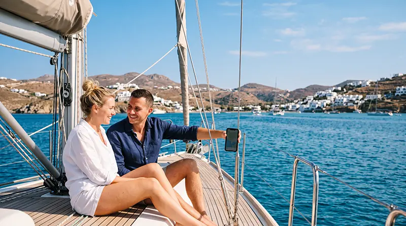 Traveler using mobile internet while sailing around the Greek Islands