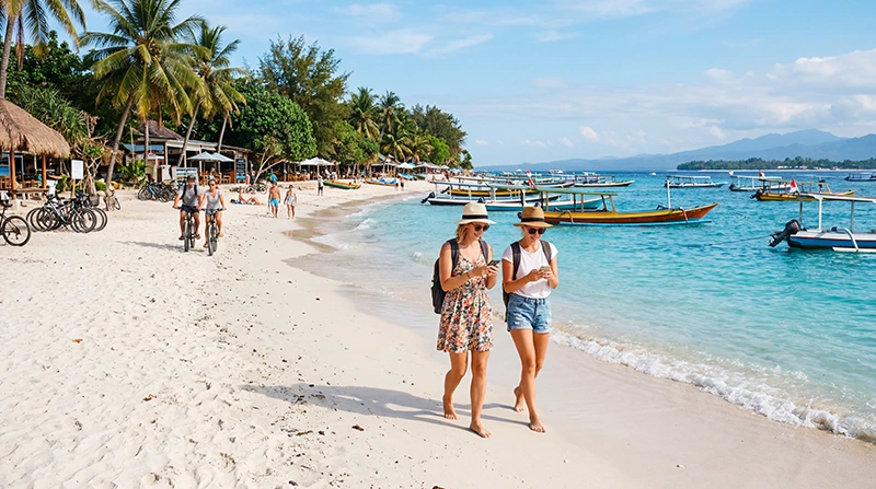 Tourists using mobile internet on smartphones while exploring the Gili Islands in Indonesia