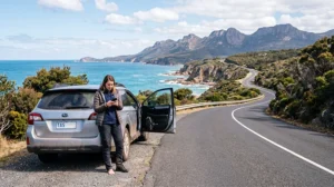 Traveler using mobile data during a Tasmania road trip while exploring coastal landscapes