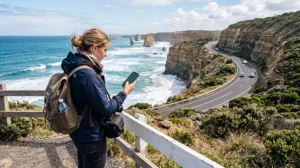 Traveler using mobile internet while exploring the Great Ocean Road in Australia