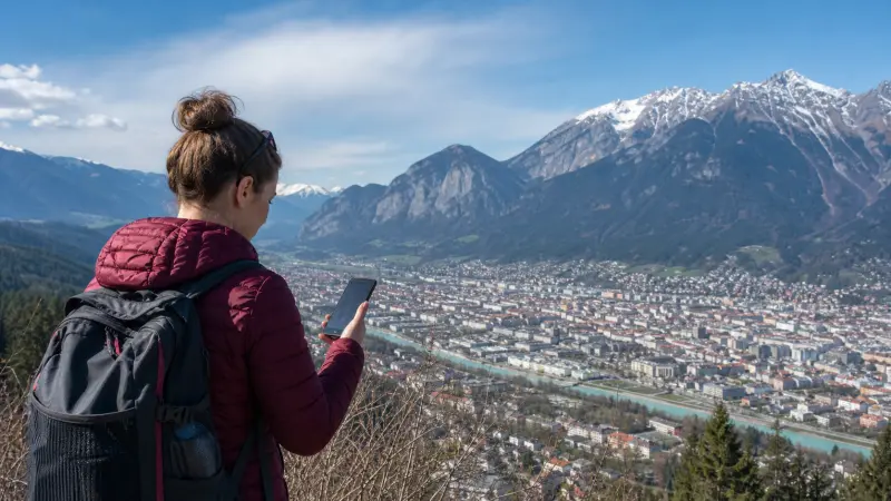 Traveller checking mobile coverage above Innsbruck and the Austrian Alps