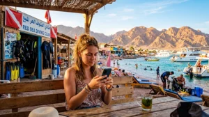 Tourist using mobile internet for diving trips in Dahab Egypt