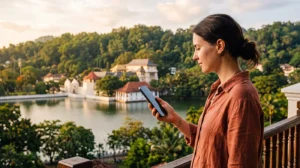 Tourist using mobile internet near Kandy Lake in Sri Lanka