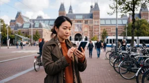 Tourist using mobile internet while visiting the Rijksmuseum in Amsterdam