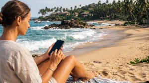 Tourist using mobile internet while visiting Tangalle Beach in Sri Lanka