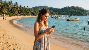 Tourist using mobile internet while visiting Unawatuna Beach in Sri Lanka