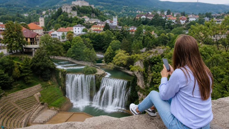 Traveller using a smartphone during mobile internet at jajce in Bosnia and Herzegovina.