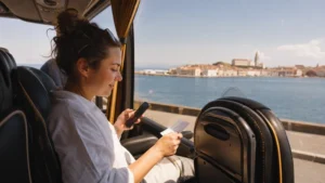 Passenger checking mobile data on a coach approaching Piran.