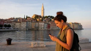 Traveller using a smartphone at Rovinj harbour.