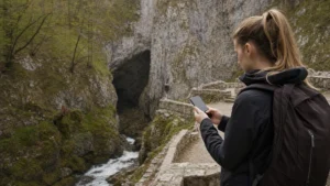 Hiker checking a smartphone near the Škocjan Caves trail.