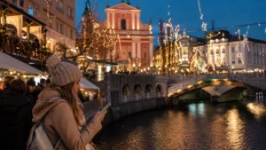 Traveller checking a smartphone at Ljubljana’s illuminated Christmas market.