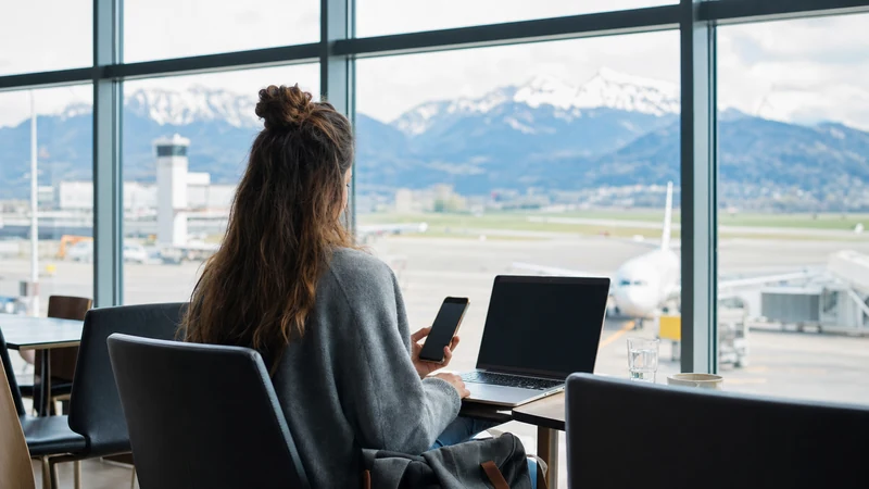 Traveller using a smartphone beside the departures area at Salzburg Airport
