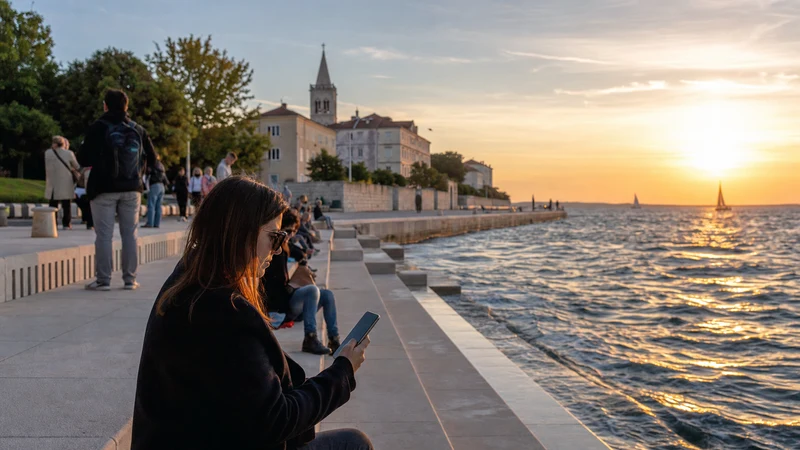 Traveller using a phone beside the Sea Organ in Zadar.