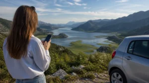 Road traveller checking mobile internet at a Lake Skadar viewpoint.