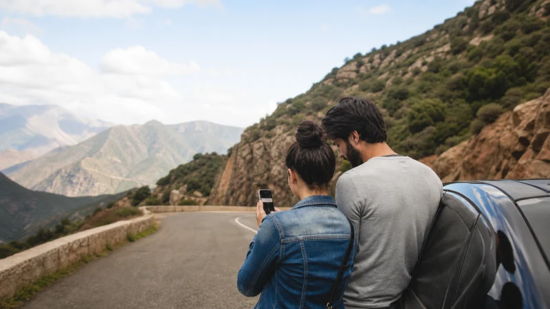 Traveller using a smartphone during a road trip in Algeria