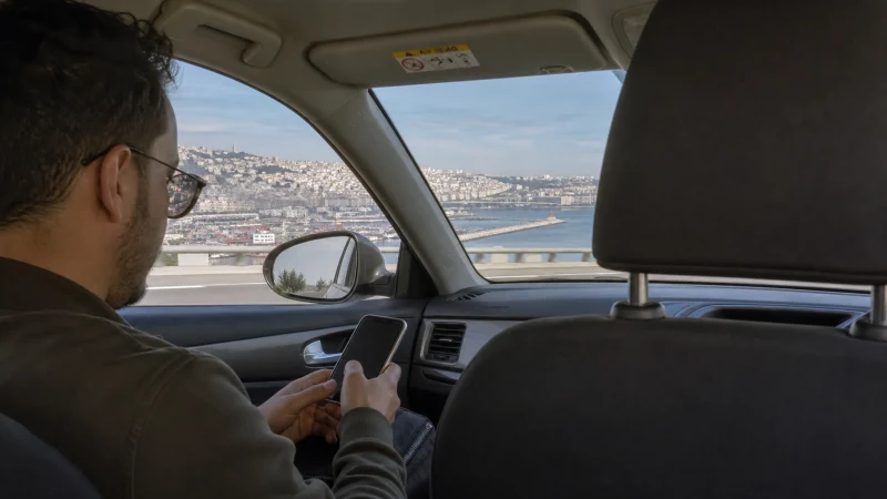 Traveller using mobile internet from Algiers Airport to the city