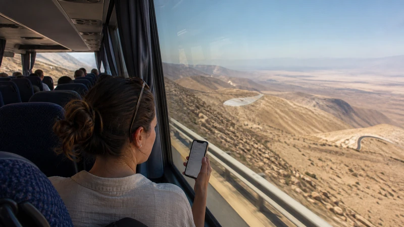 Traveller using a smartphone in Jordan for amman to petra mobile internet: road, rail and flight guide