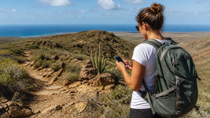 Hiker checking mobile reception in Arikok National Park Aruba