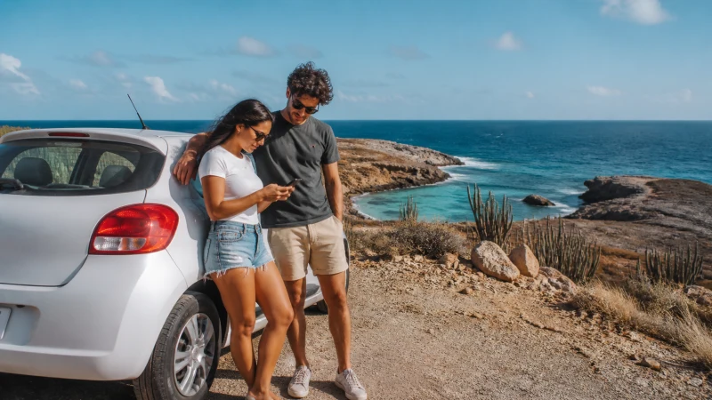 Travellers using mobile navigation on an Aruba road trip