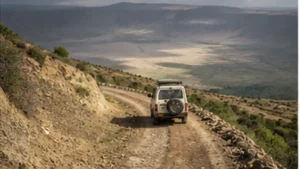 Traveller using a smartphone between Arusha and Ngorongoro