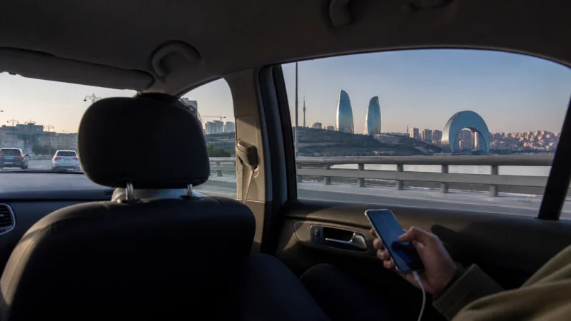 Traveller using mobile internet during a Baku Airport city transfer