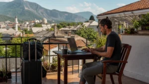 Long-stay traveller working with a laptop and smartphone on a Balkan terrace