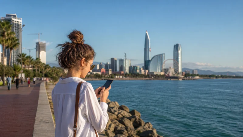 Traveller using a smartphone on the Batumi seaside boulevard
