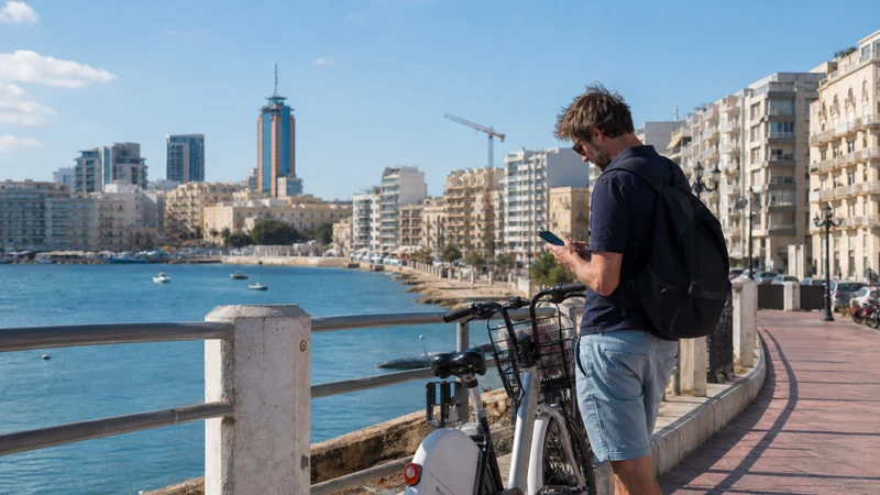 Traveller using a smartphone in Malta while choosing a mobile network for a Malta trip
