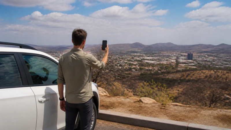 Traveller using a smartphone in Namibia while choosing a network for a Namibia trip