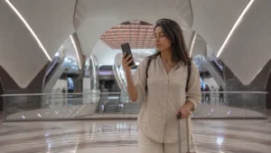 Traveller using a smartphone in a Doha Metro station concourse
