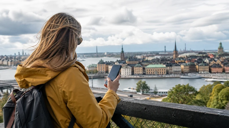 Traveller using a smartphone while preparing for which swedish mobile network is best for tourists