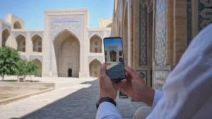 Traveller checking mobile service above historic Samarkand