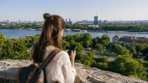 Traveller using a smartphone above the Danube and Sava confluence in Belgrade.