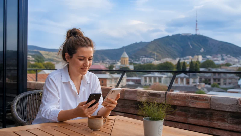 Traveller comparing smartphone internet options on a Tbilisi terrace