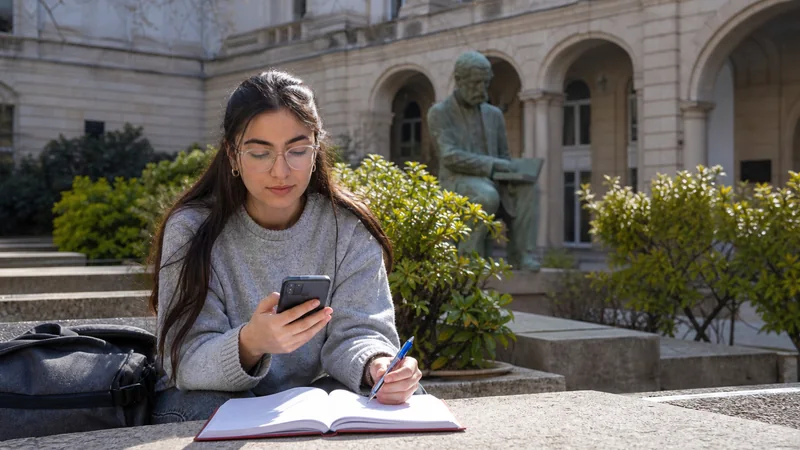 Student traveller using a smartphone and notebook in Bulgaria