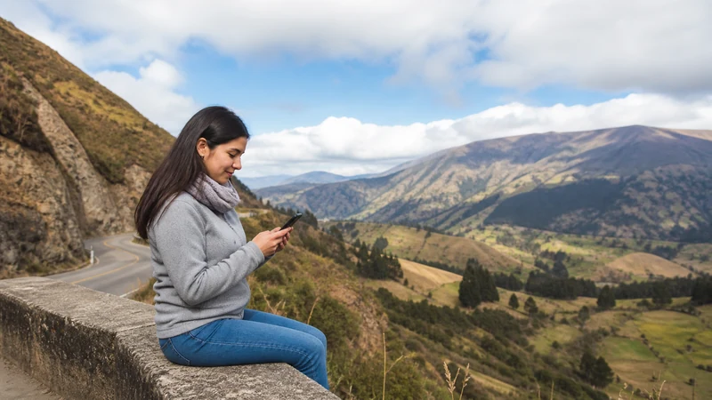 Traveller using a smartphone in Colombia for mobile data near the colombia–ecuador border