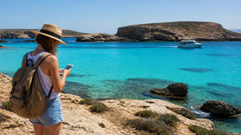 Traveller using a smartphone during a Comino day trip