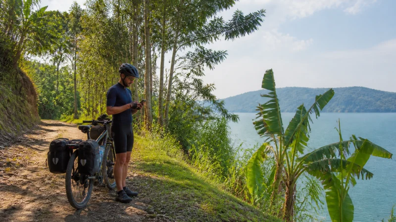 Cyclist checking a smartphone on the Congo Nile Trail
