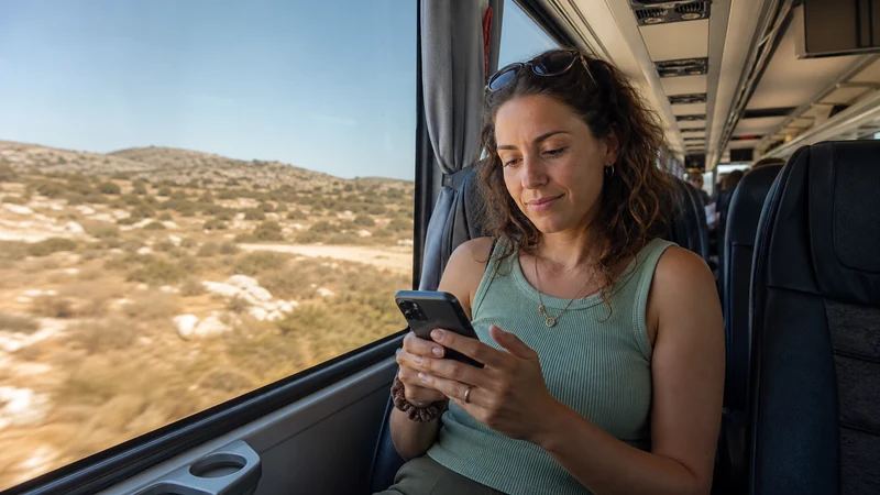 Traveller using a smartphone during cyprus bus wifi and mobile data