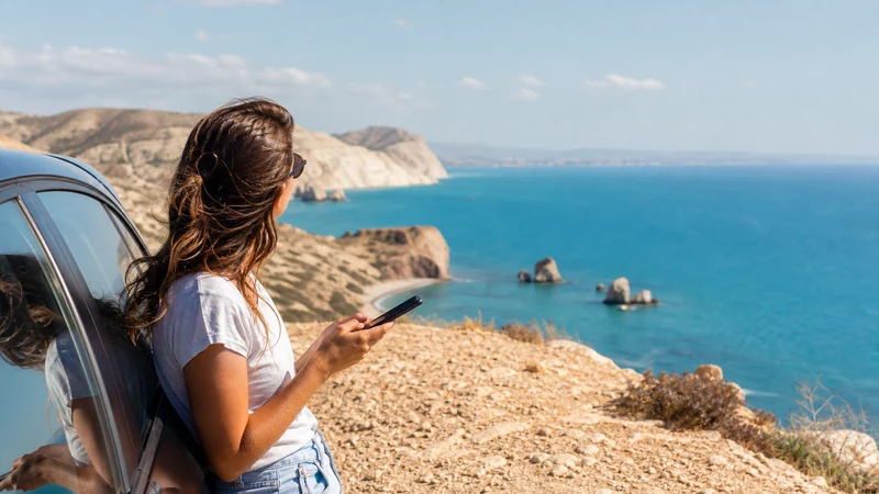 Traveller using a smartphone during cyprus road trip mobile internet