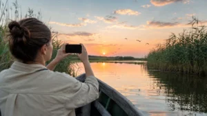 Traveller using a smartphone during danube delta in Romania.