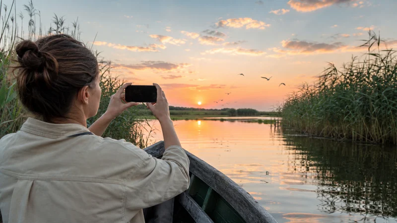 Traveller using a smartphone during danube delta in Romania.