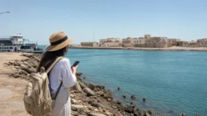 Traveller using a smartphone in a Kuwait setting related to will your phone work on failaka island?