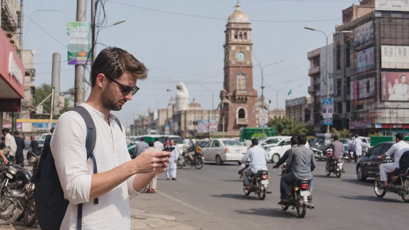 Traveller using mobile data near Faisalabad Clock Tower